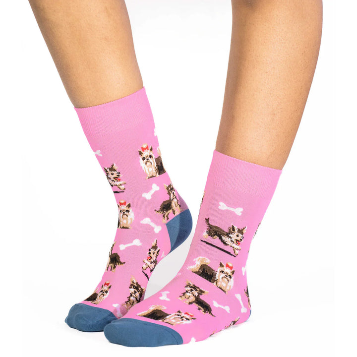 Pink socks with dog pattern worn by a person on a white background