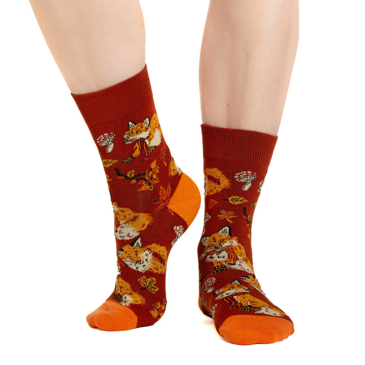 Red socks with fox pattern worn by a person on a white background