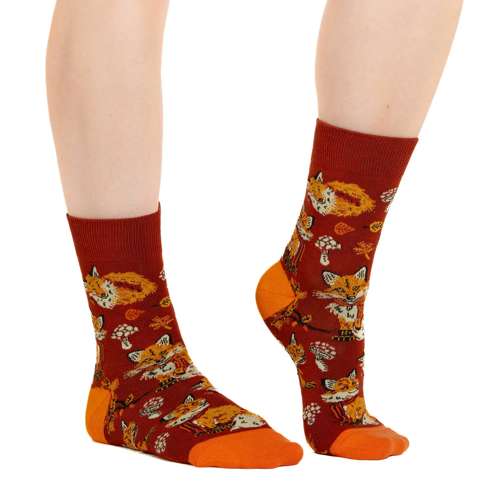 Red socks with fox pattern worn by a person on a white background
