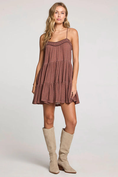 Woman wearing a brown polka dot dress with beige knee-high boots on a white background