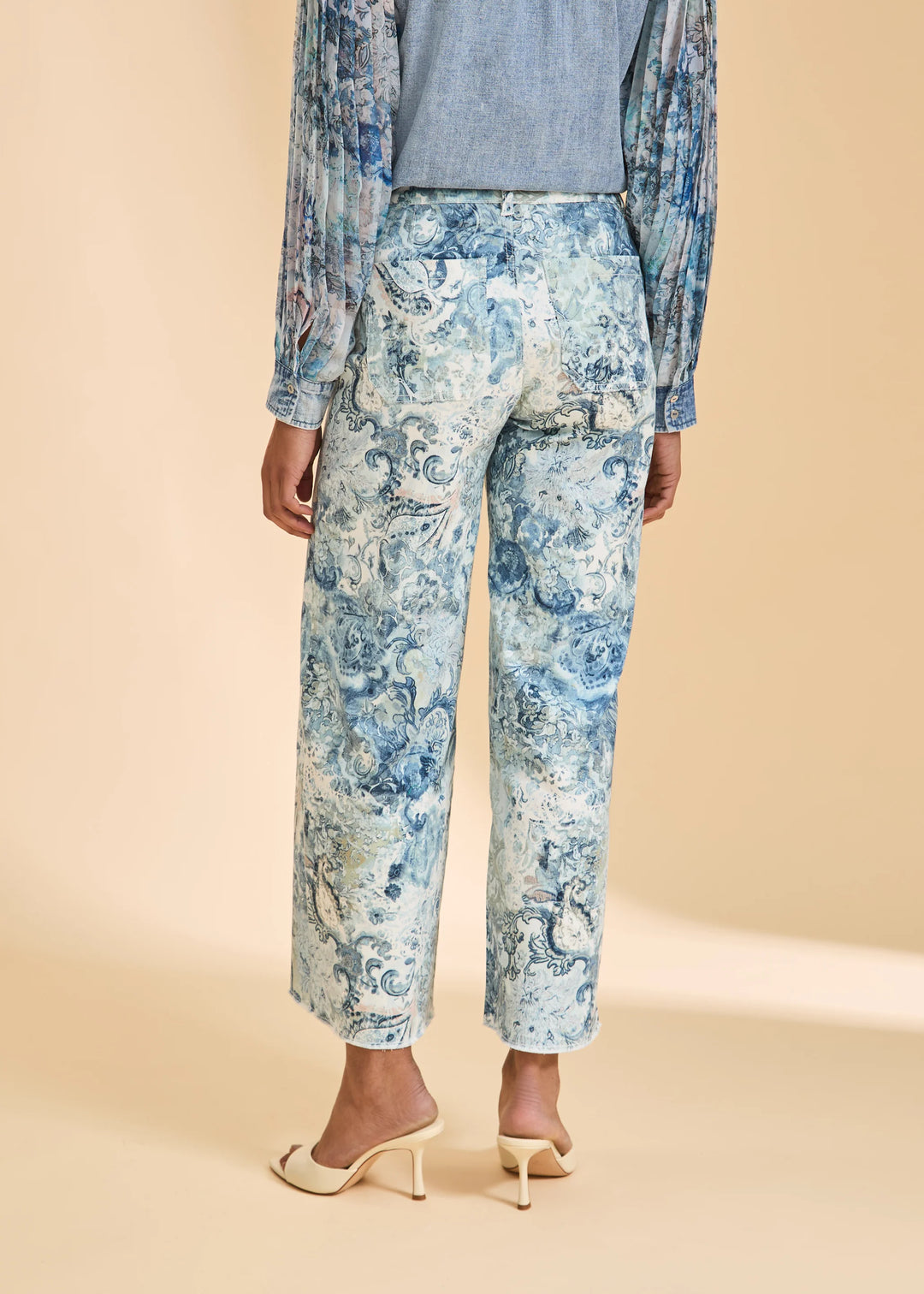 Person wearing a floral outfit with a beige background