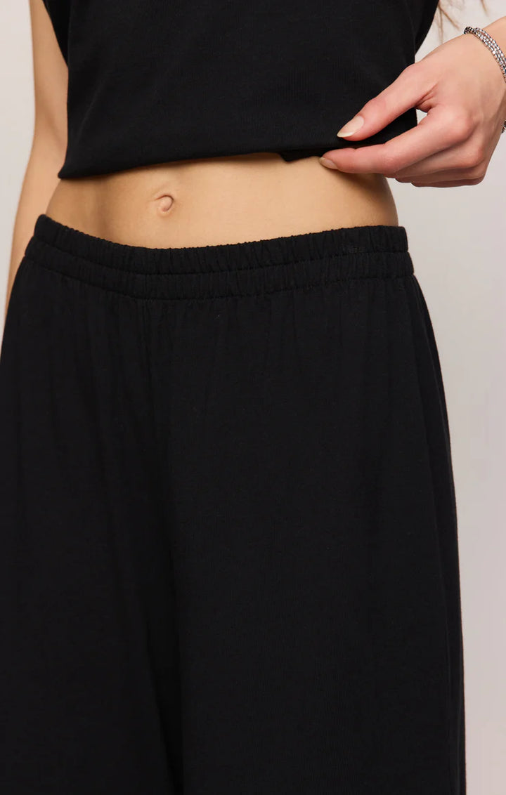 Person wearing a black skirt with a plain background