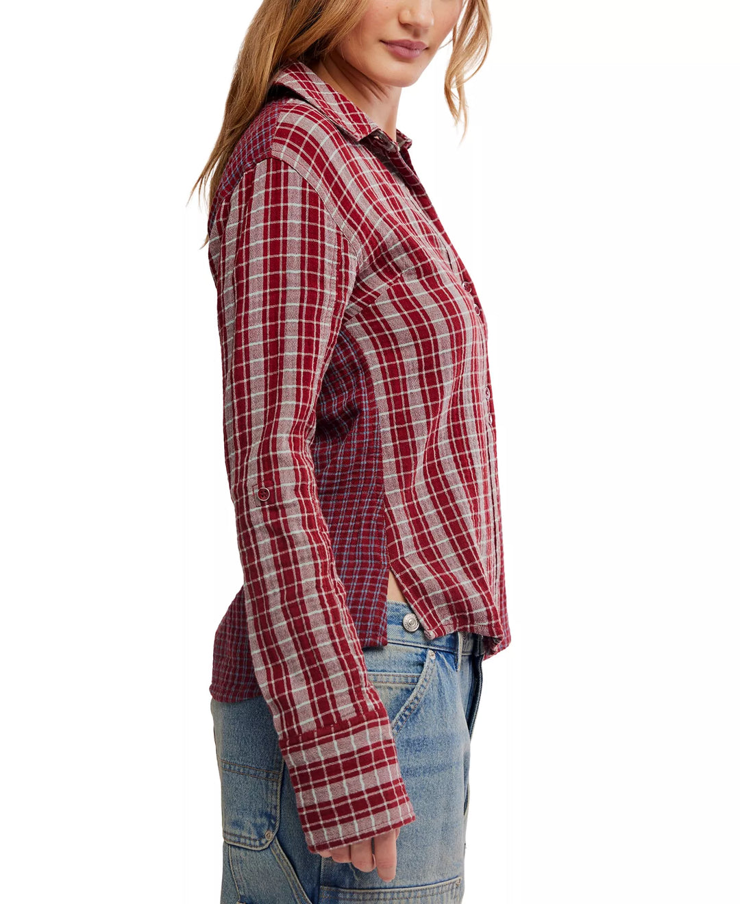 A woman shown in side profile wearing a red and white plaid button-up shirt with blue jeans against a plain white background.