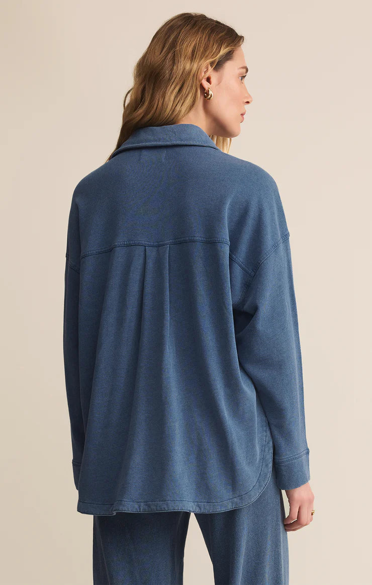 Woman wearing a blue jacket on a beige background