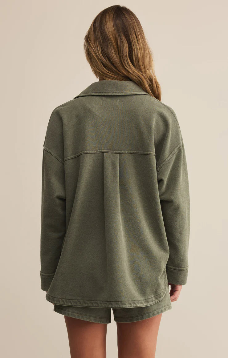 Person wearing a green jacket on a beige background
