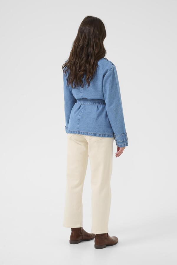 Person wearing a blue denim jacket and white pants on a white background