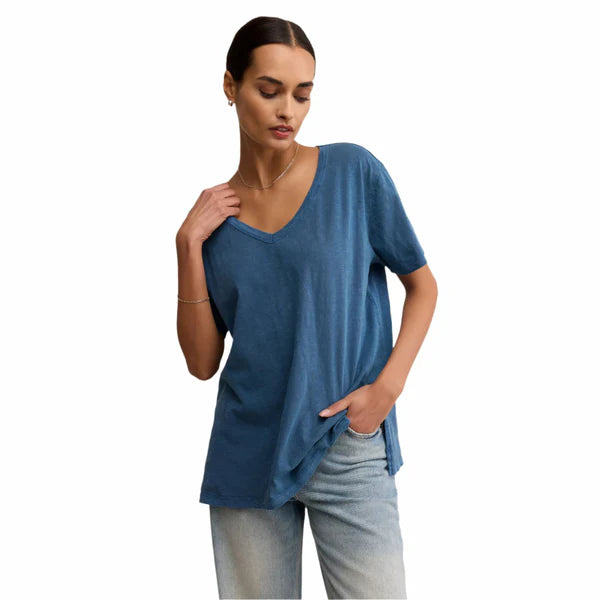 Woman wearing a blue t-shirt and light jeans on a white background