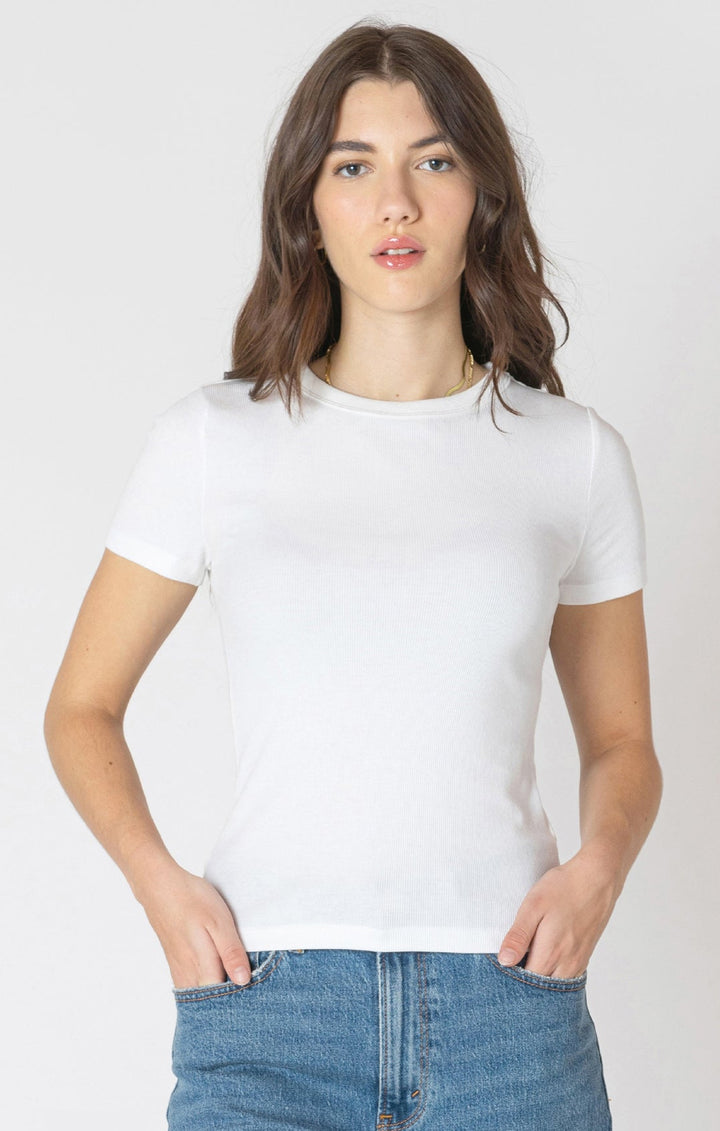 Woman wearing a white t-shirt and blue jeans against a plain background