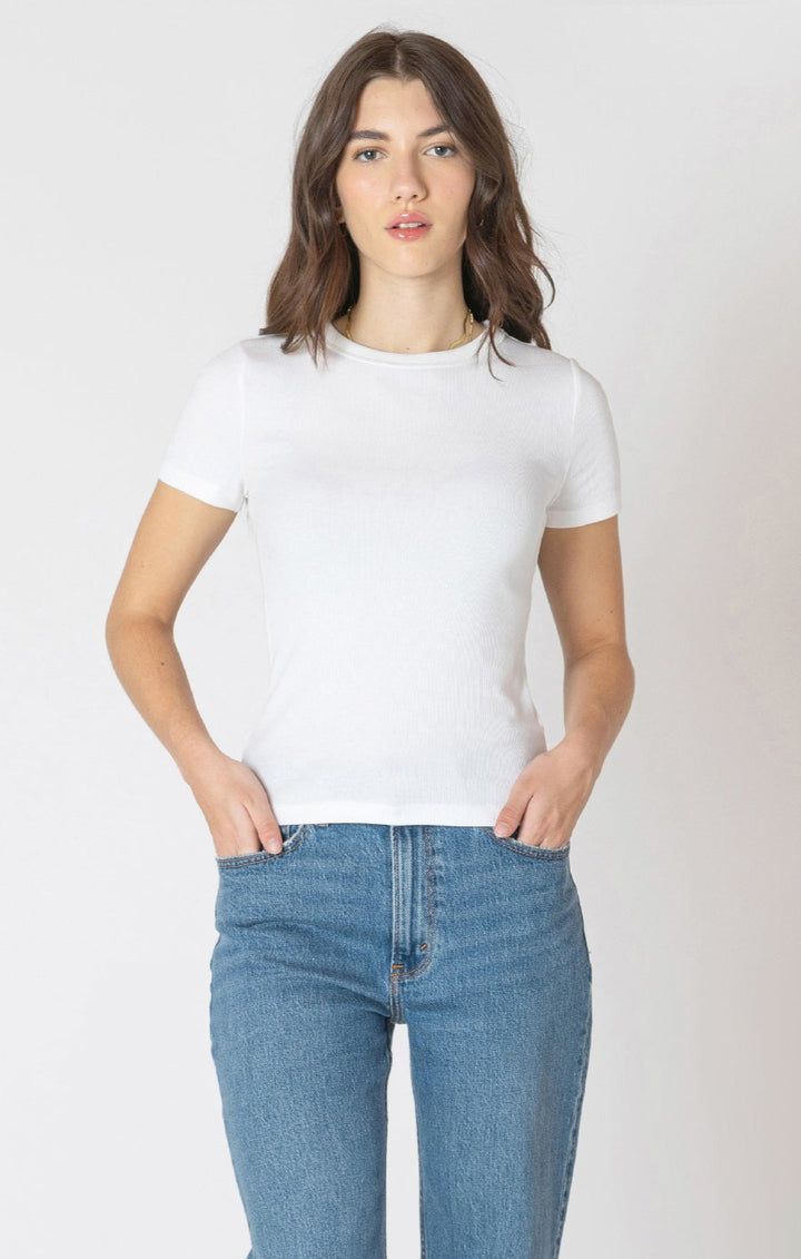 Woman wearing a white t-shirt and blue jeans against a plain background