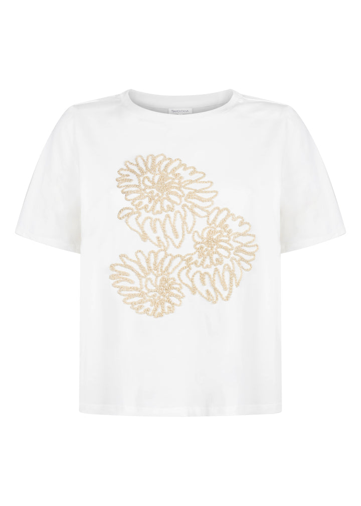 White t-shirt with gold floral patterns on a white background