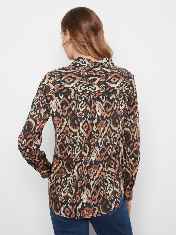 A woman shown from the back wearing a long-sleeve button-up shirt with an intricate brown, beige, and black geometric pattern, paired with blue jeans against a plain white background.