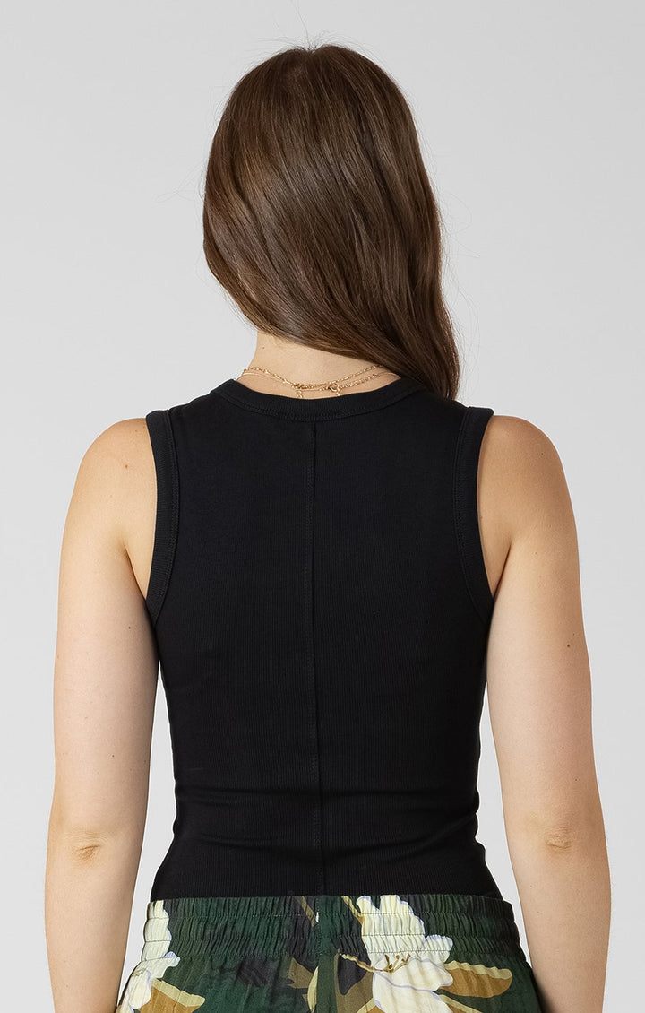 Woman wearing a black top and green floral skirt on a white background