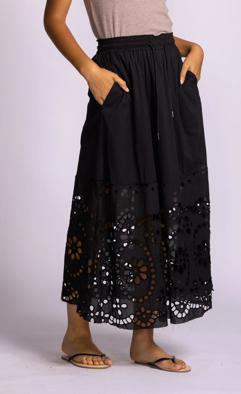 Black lace-trimmed pants worn by a person on a white background