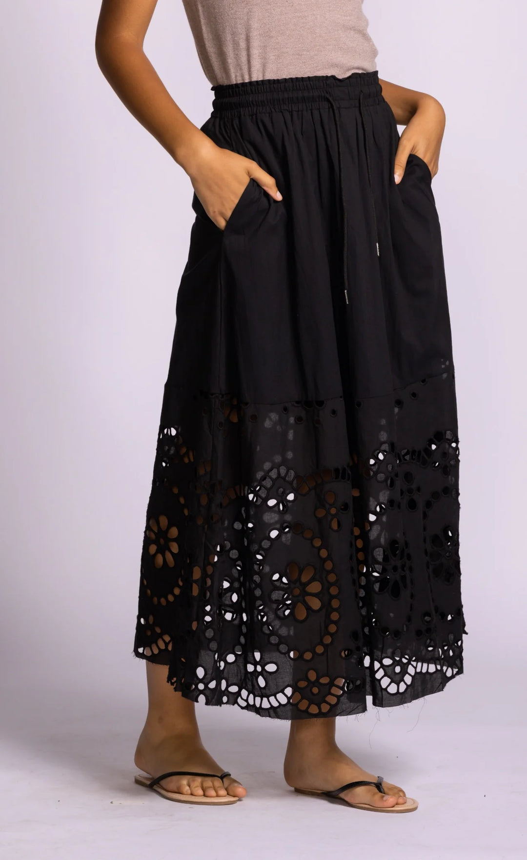 Black lace-trimmed pants worn by a person on a white background