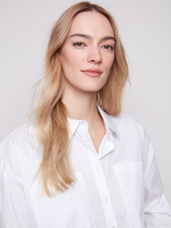Woman wearing a white shirt against a plain background