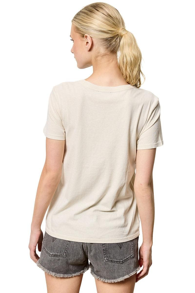Woman wearing a beige t-shirt and denim shorts on a white background