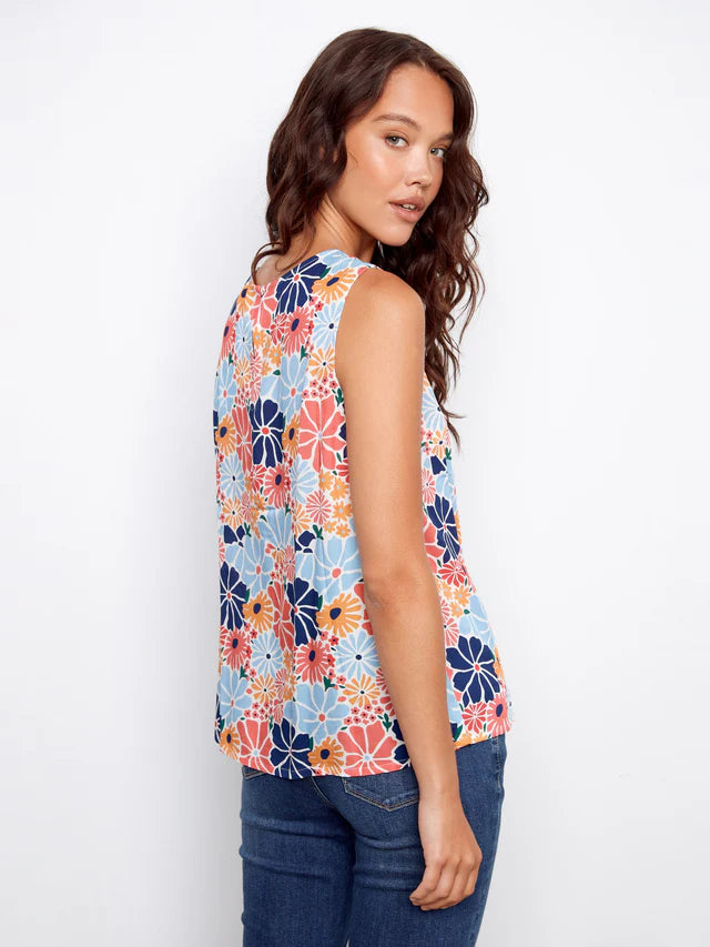 Woman wearing a colorful floral sleeveless top against a white background