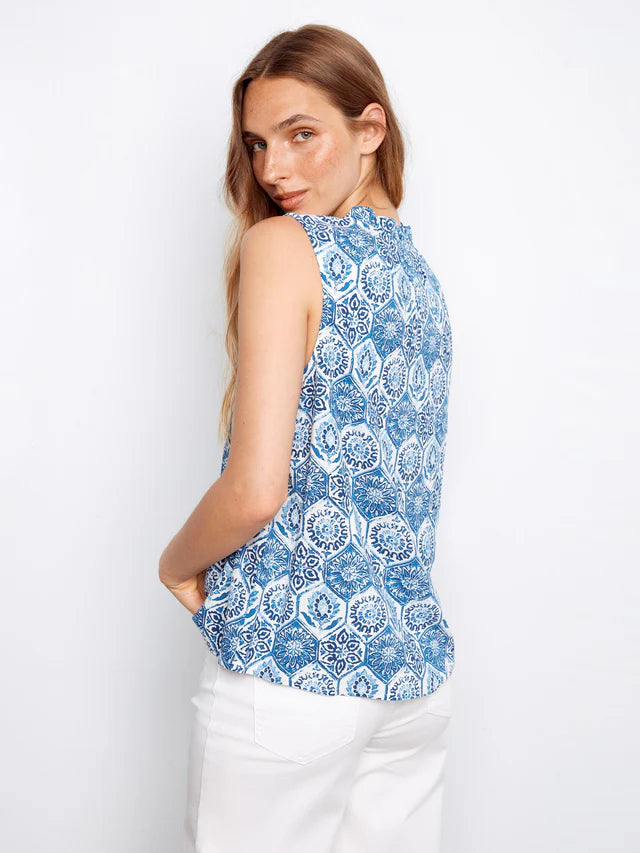Woman wearing a blue and white patterned sleeveless top on a white background