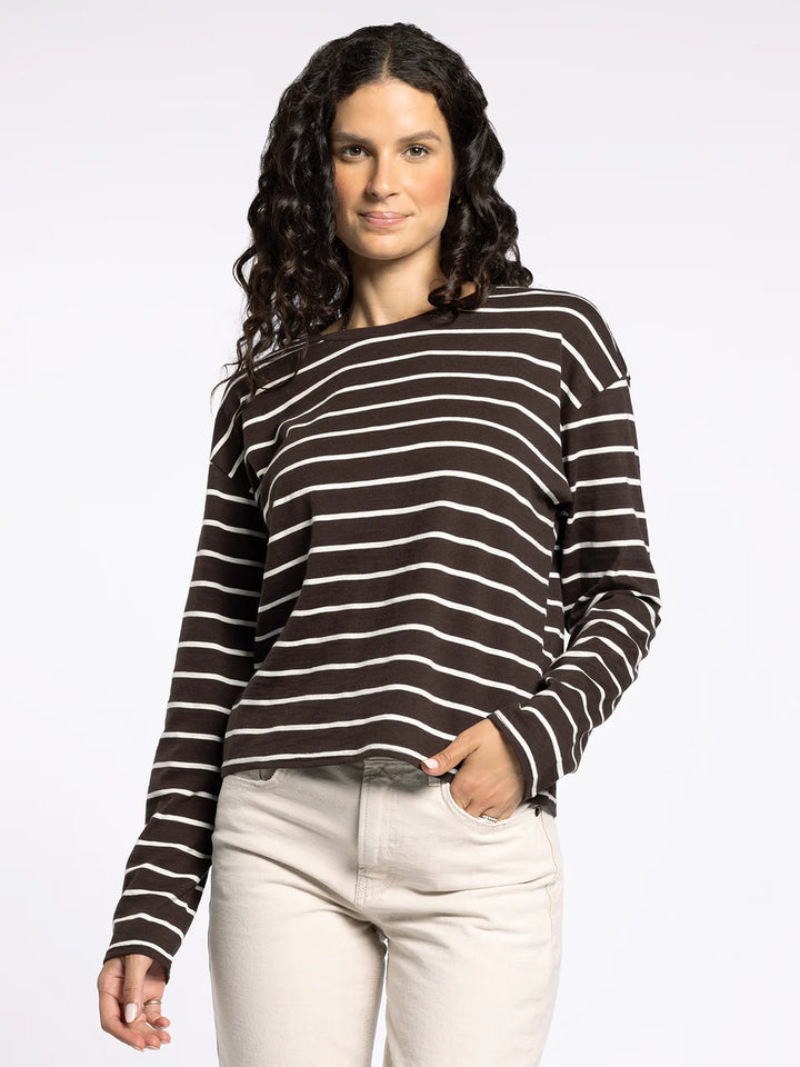 Woman wearing a black and white striped sweater on a plain background