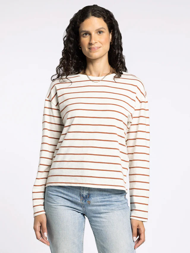 Woman wearing a striped long-sleeve shirt and jeans on a white background