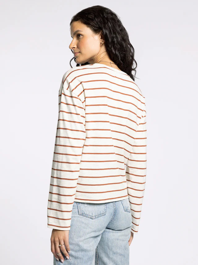 Woman wearing a striped long-sleeve shirt and jeans on a white background
