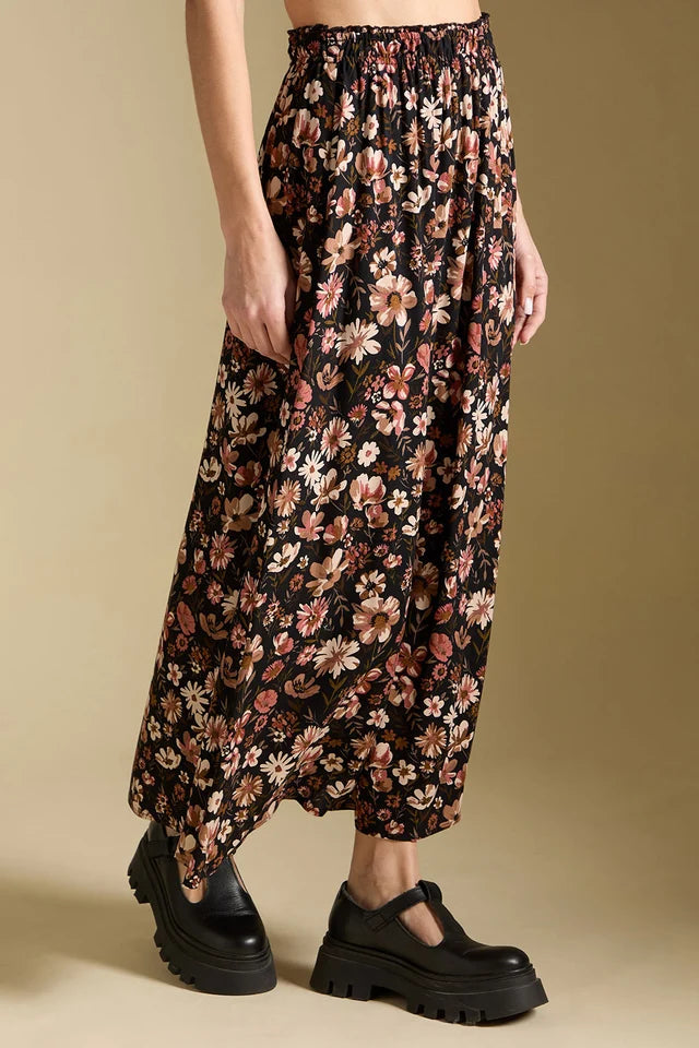 Floral patterned pants worn by a person on a beige background