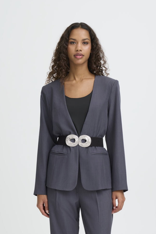 Woman wearing a gray suit with a belt on a white background