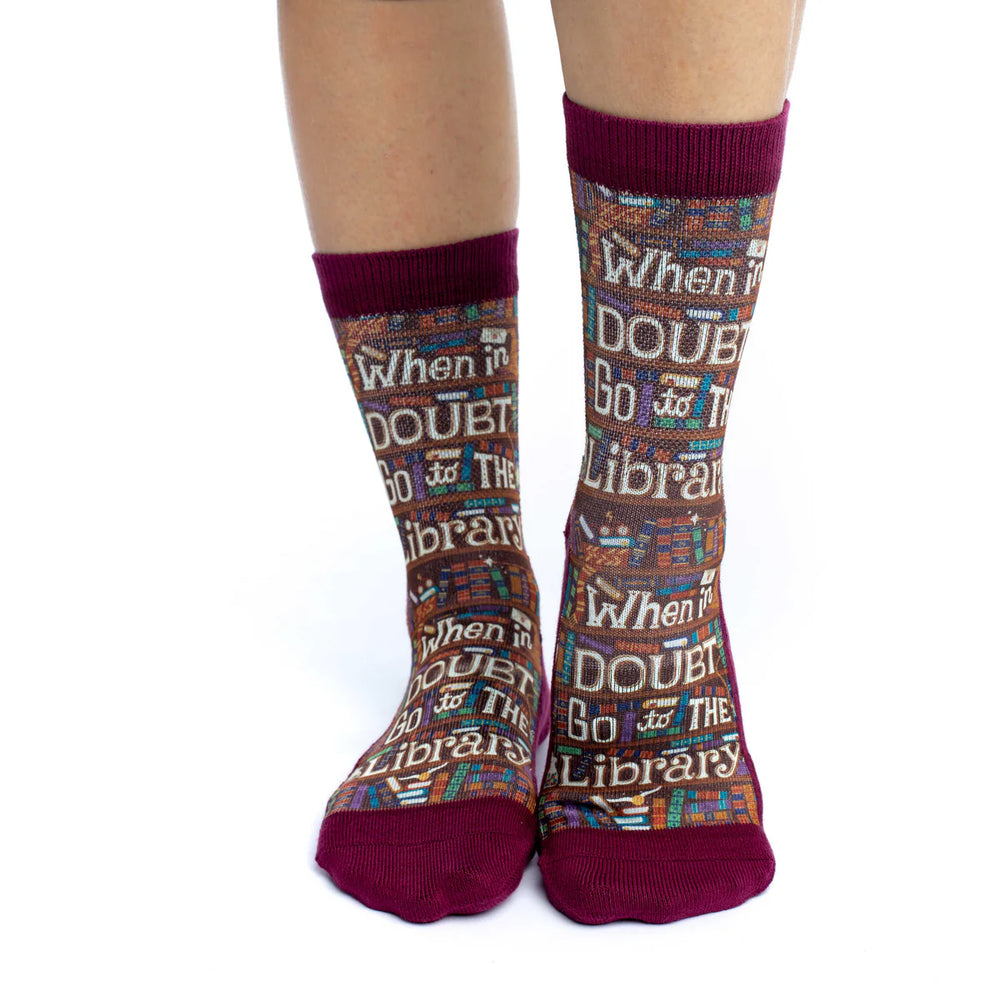 Socks with library-themed text worn by a person on a white background