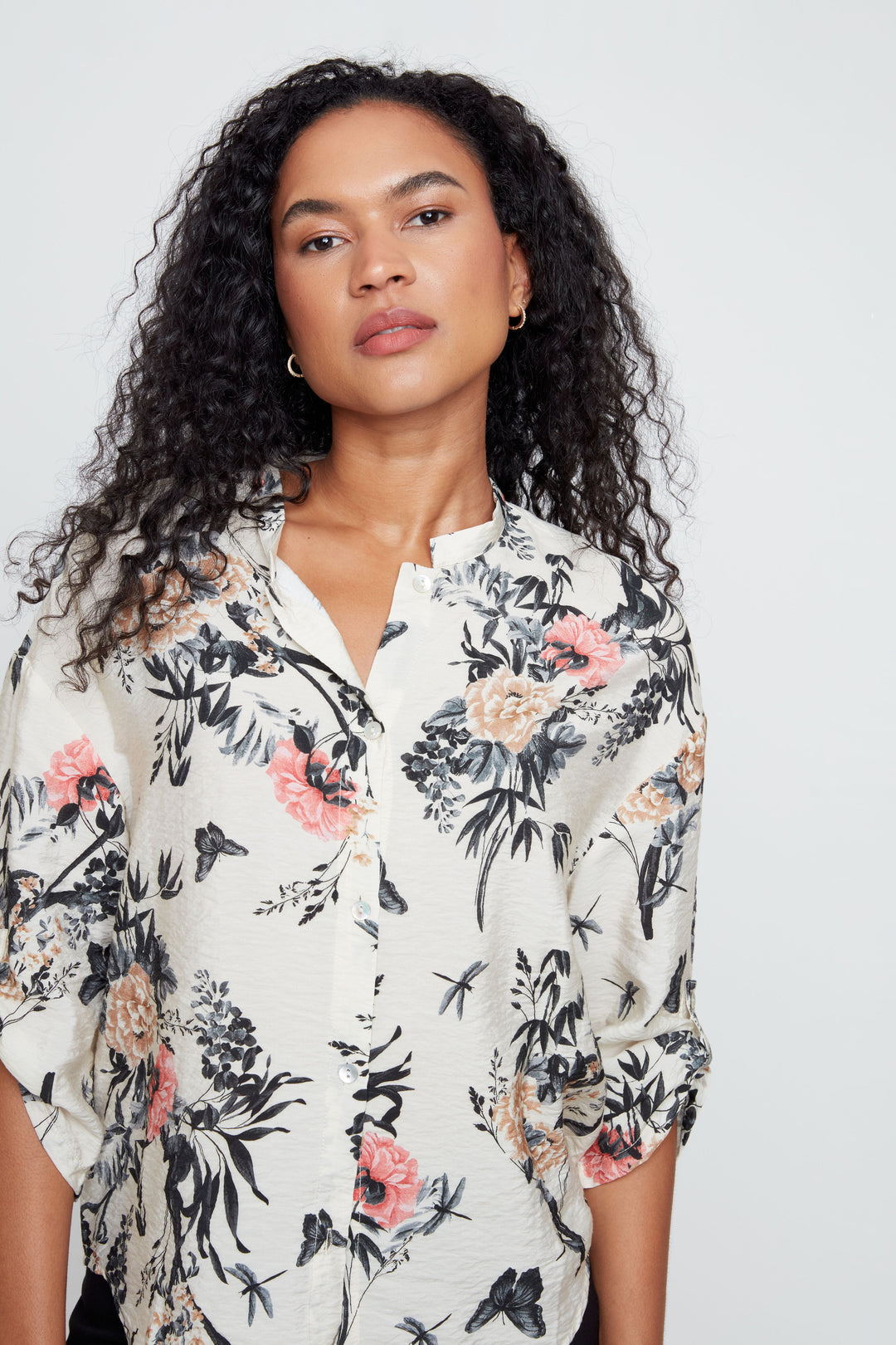 Woman wearing a floral blouse against a plain background