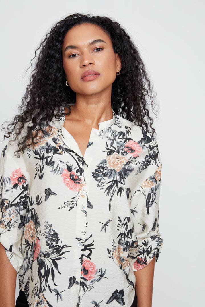 Woman wearing a floral blouse against a plain background