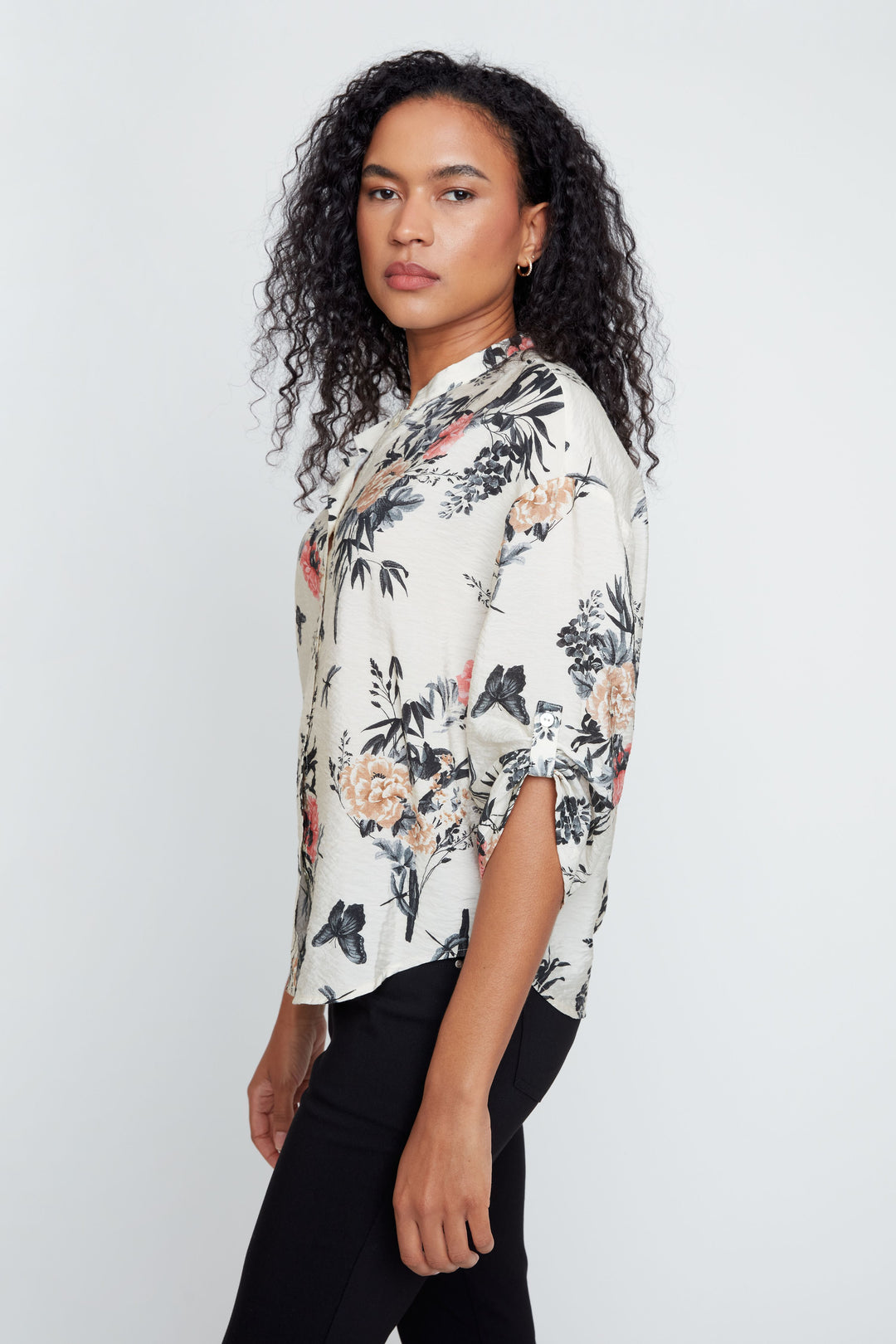 Woman wearing a floral blouse against a white background