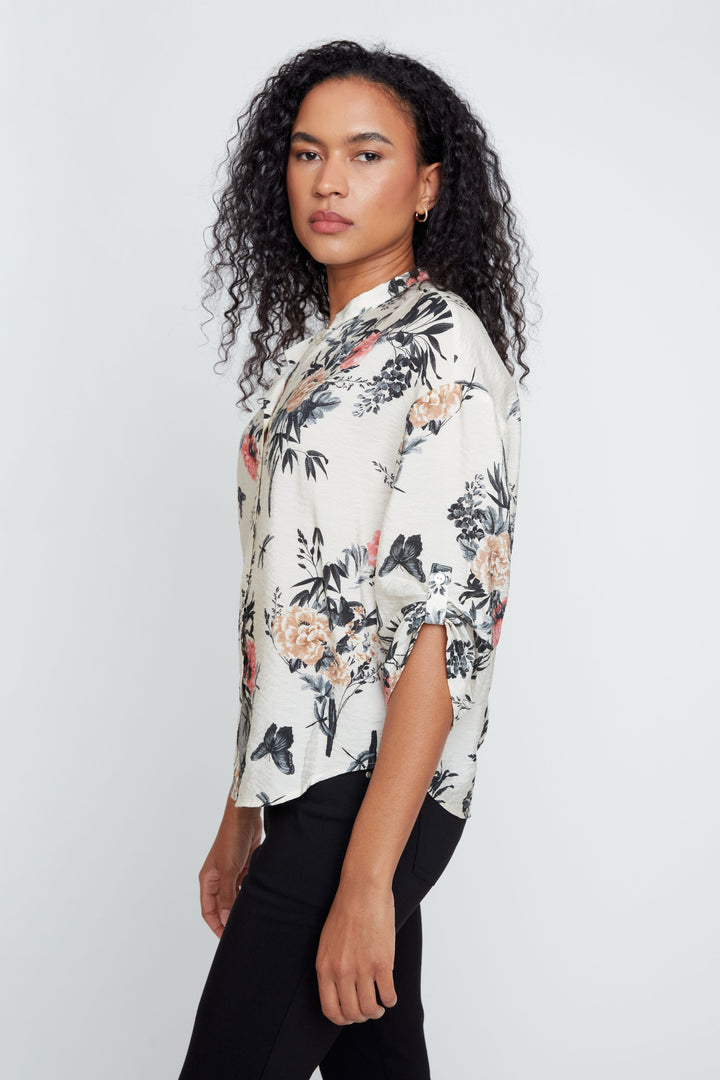 Woman wearing a floral blouse against a white background