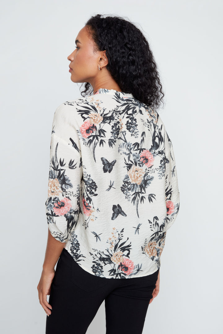 Woman wearing a floral blouse against a white background