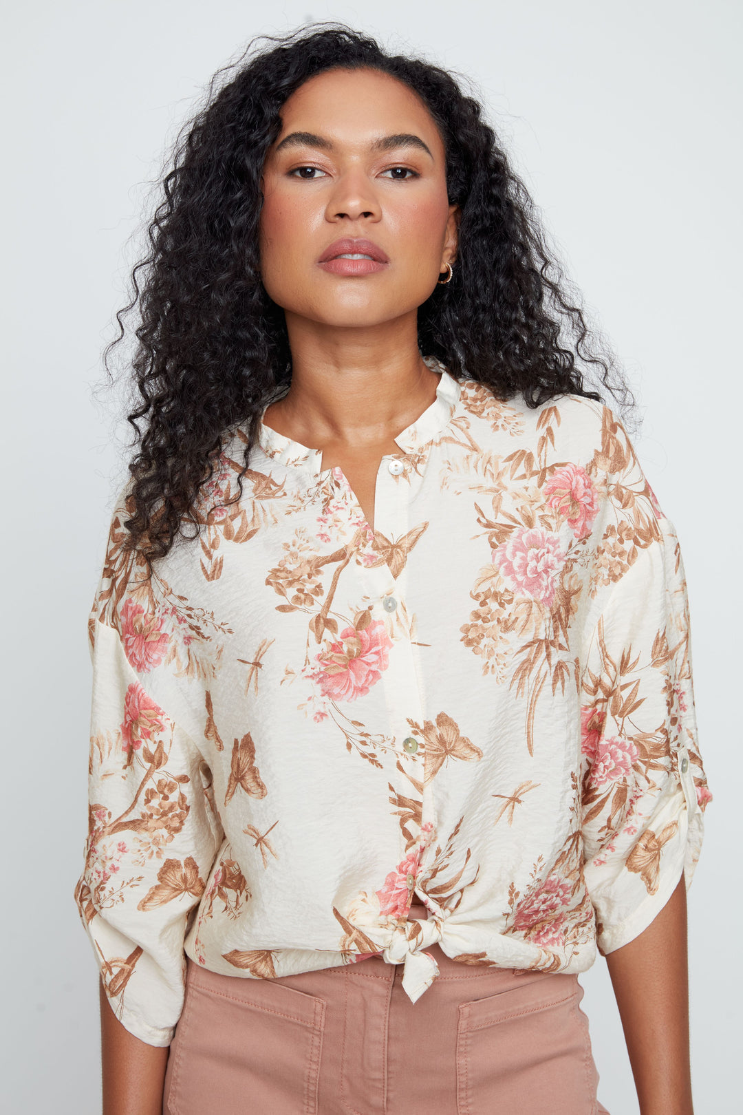 Woman wearing a floral blouse against a plain background