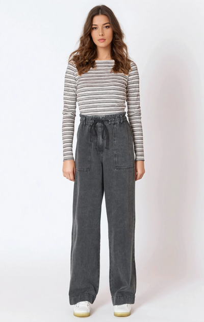 Woman wearing a striped long-sleeve top and gray wide-leg pants on a white background