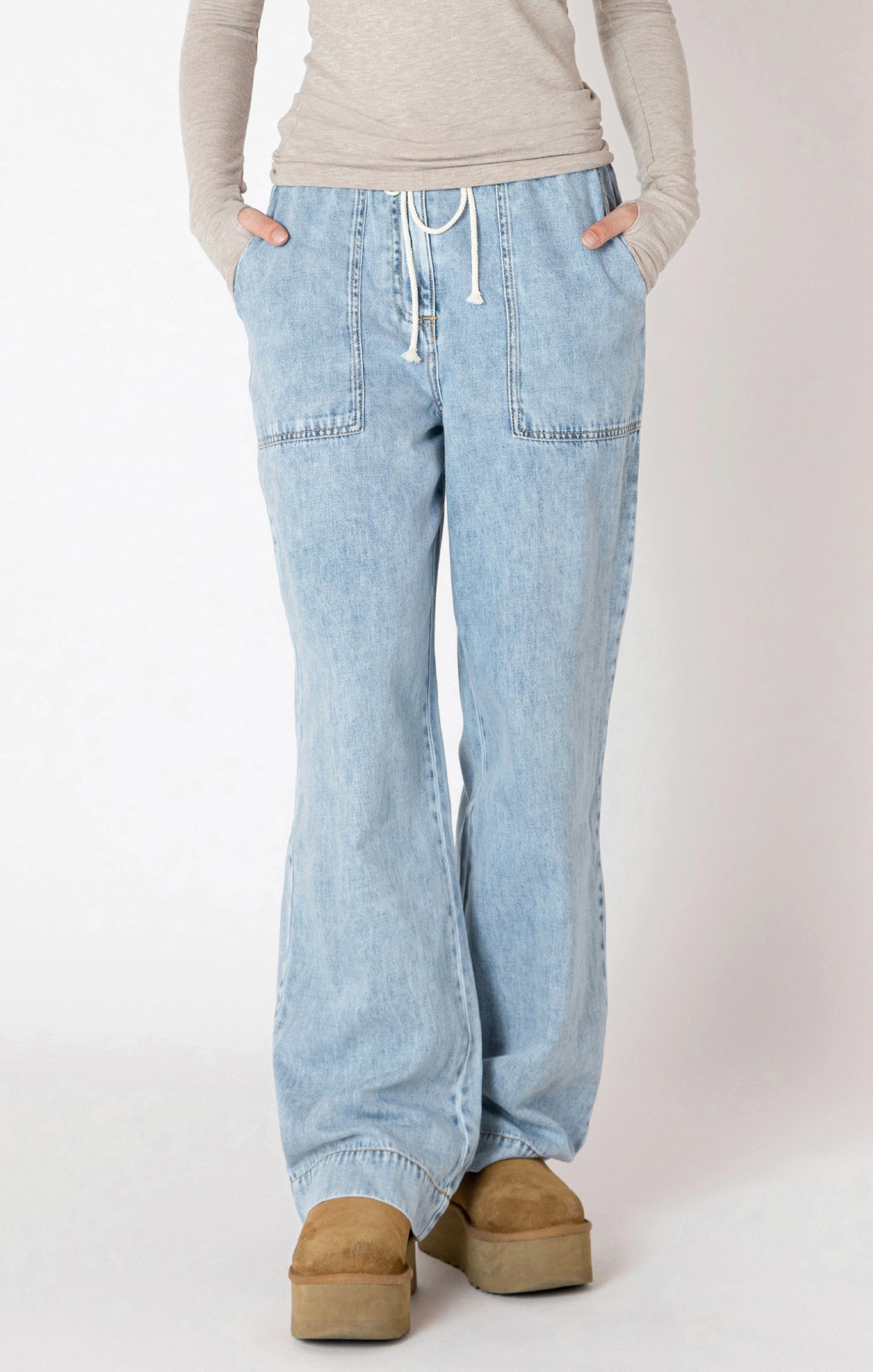 Light blue jeans worn by a person on a white background