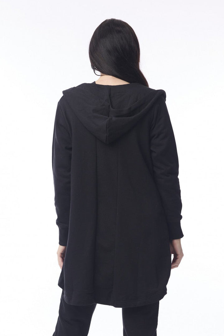 Person wearing a black hooded coat and pants on a white background
