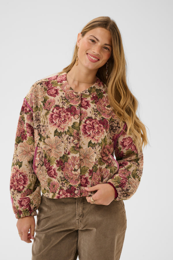 Woman wearing a floral blouse with a plain background