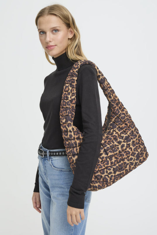 Woman holding a leopard print bag against a white background