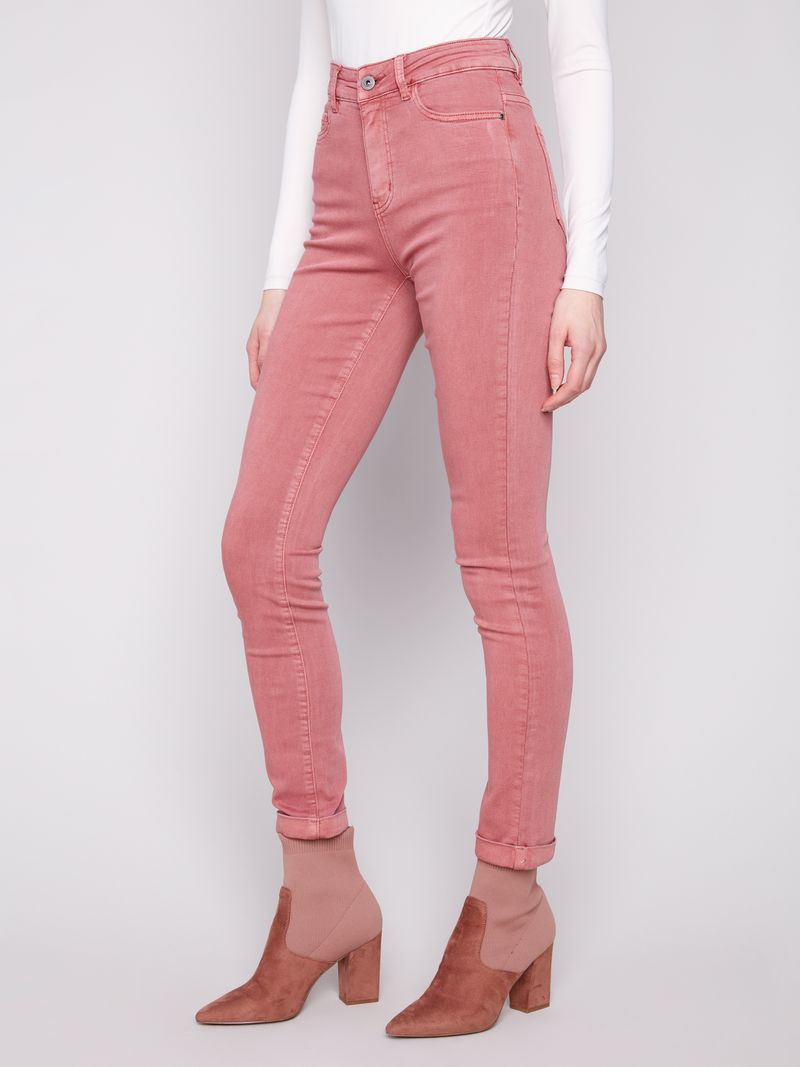 Person wearing pink jeans and matching boots on a white background