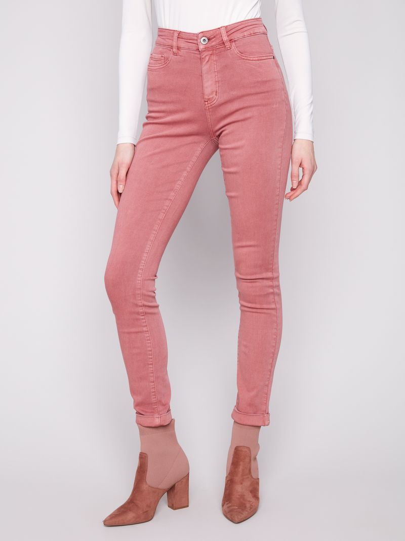 Person wearing pink jeans and brown boots on a white background