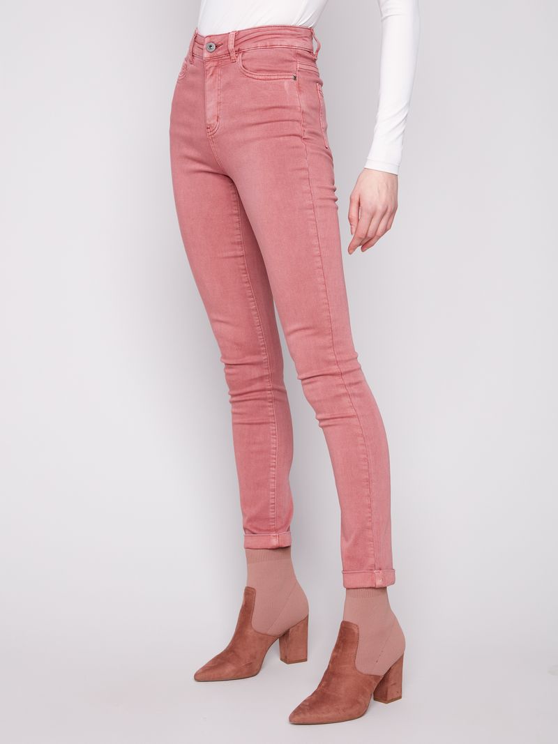 Person wearing pink jeans and matching shoes on a white background
