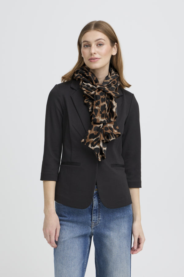 Woman wearing a black blazer and leopard print scarf on a light gray background