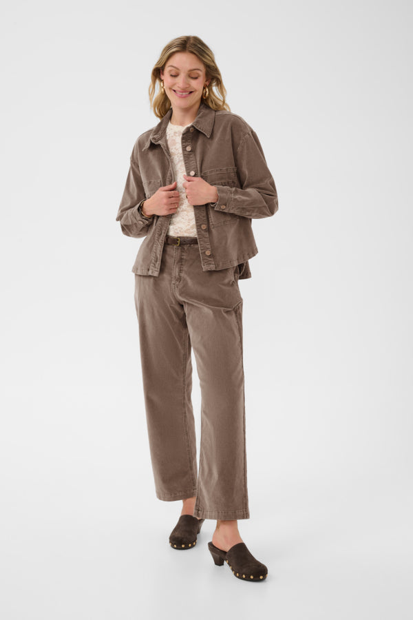 Woman wearing a brown jacket and pants on a white background
