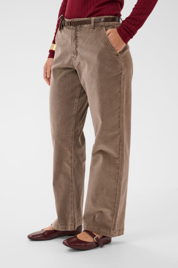 Person wearing beige pants with a red sweater on a white background