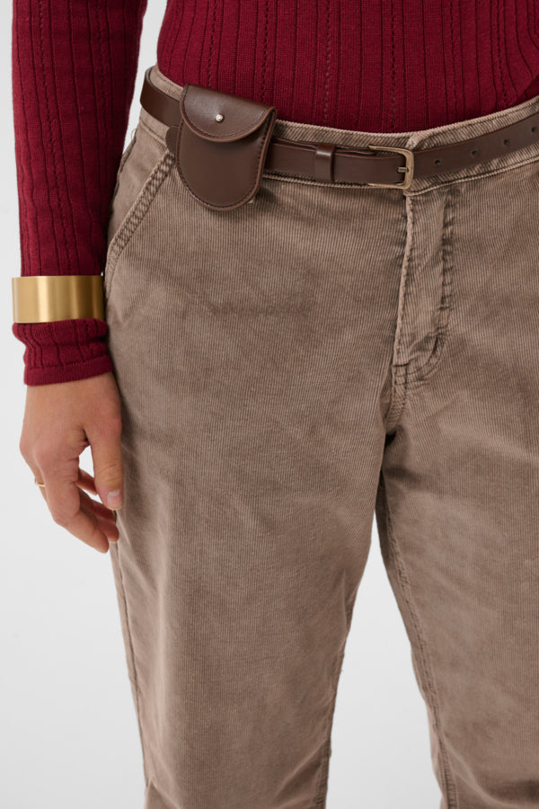 Brown pants with a belt and gold bracelet on a white background