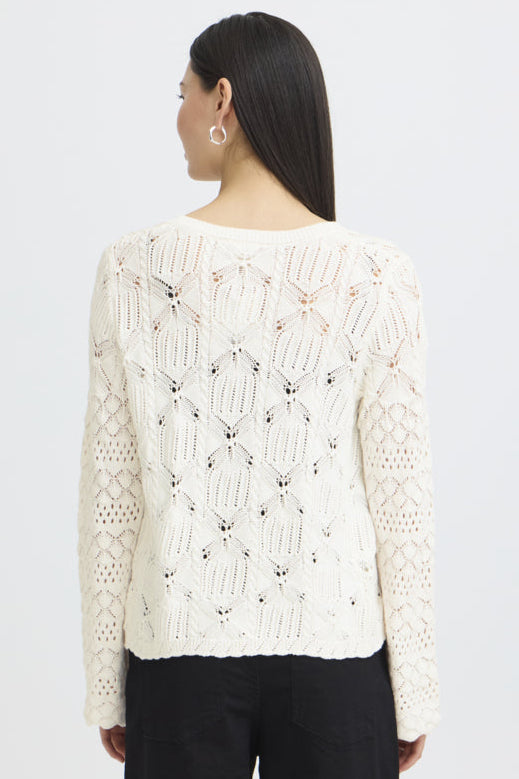 Woman wearing a cream lace sweater on a white background