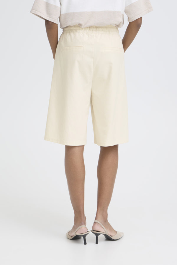 Person wearing light-colored shorts on a white background