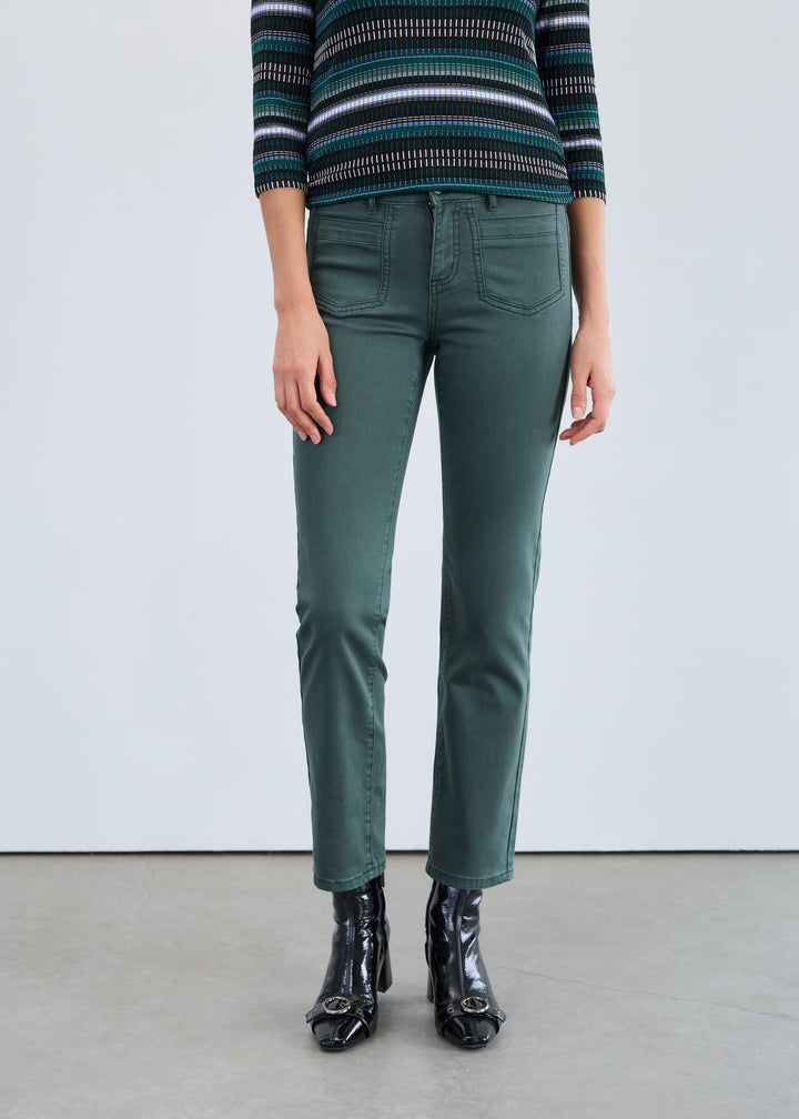 Person wearing green pants and a striped sweater on a plain background