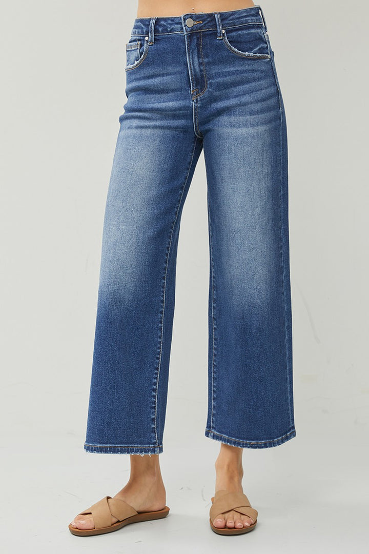 Blue jeans worn by a person on a gray background